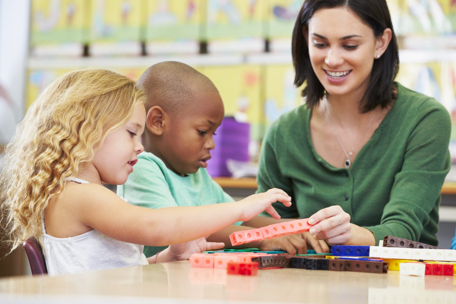 Math teacher tutoring a small group with manipulatives